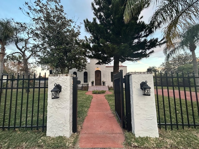 view of gate with a lawn