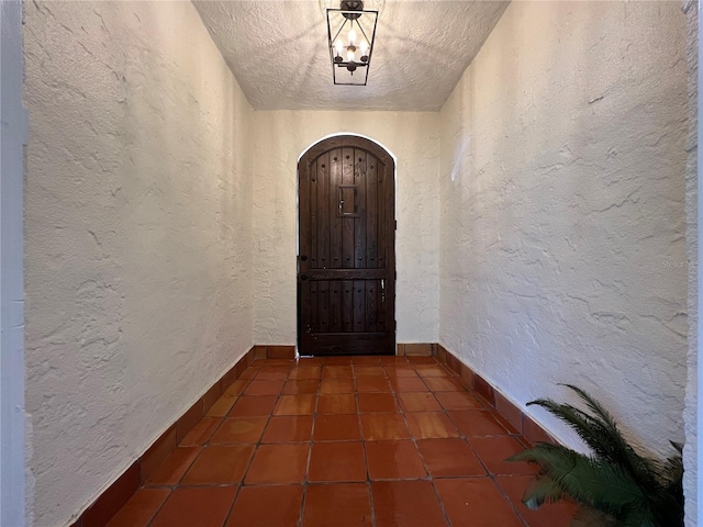 hallway with dark tile patterned floors and a textured ceiling