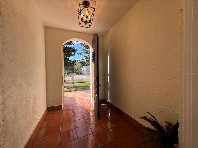 tiled entrance foyer with a notable chandelier and a textured ceiling