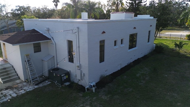 exterior space featuring central AC and a lawn