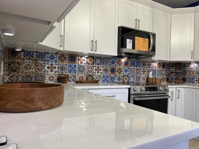 kitchen with light stone counters, decorative backsplash, stainless steel range with electric cooktop, and white cabinets