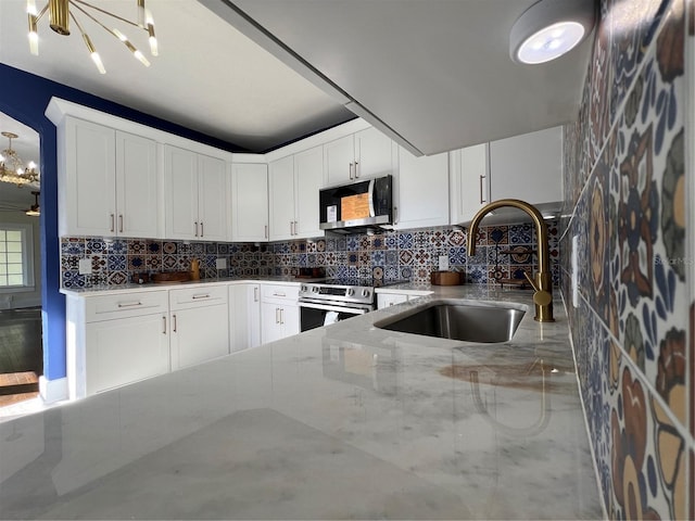 kitchen with an inviting chandelier, sink, white cabinets, and appliances with stainless steel finishes