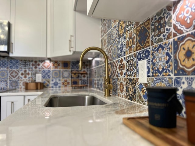 kitchen with light stone counters, sink, and decorative backsplash