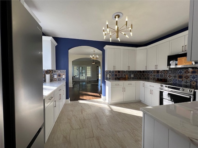 kitchen with hanging light fixtures, a notable chandelier, white cabinets, and appliances with stainless steel finishes