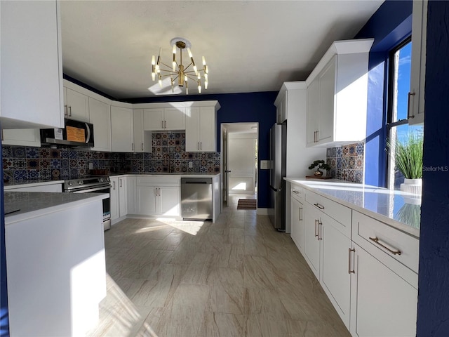 kitchen featuring white cabinetry, hanging light fixtures, tasteful backsplash, and appliances with stainless steel finishes