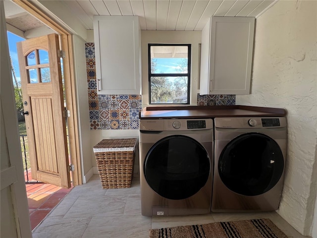 washroom with cabinets, wood ceiling, and washer and clothes dryer