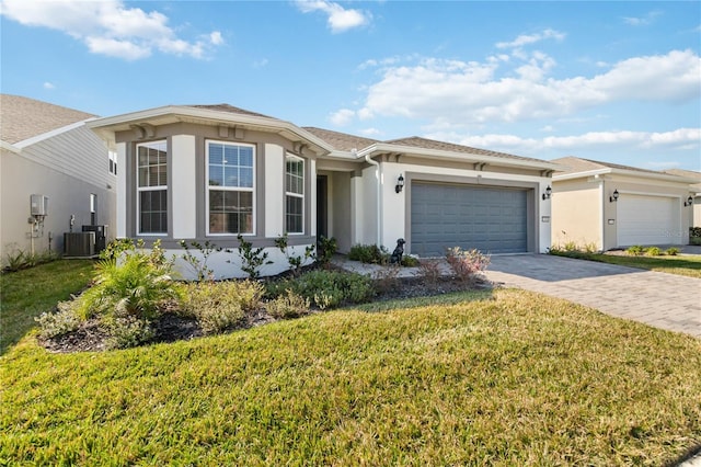 ranch-style home with a garage, central AC, and a front yard