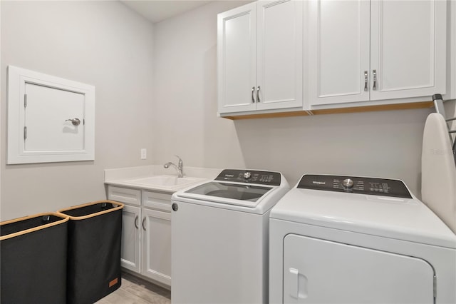 laundry room featuring separate washer and dryer, sink, cabinets, and light wood-type flooring