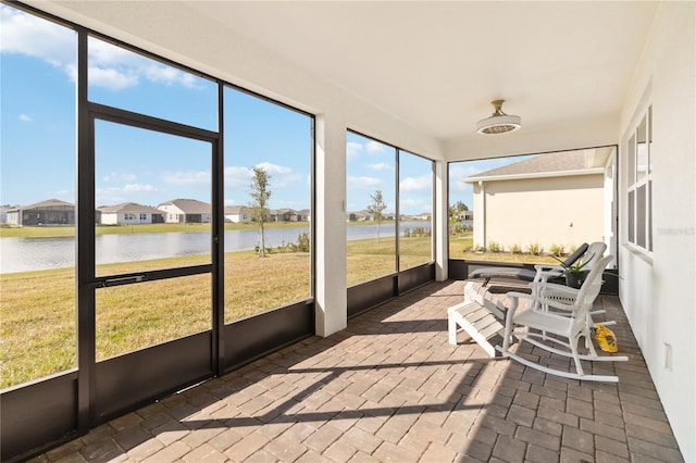 sunroom / solarium featuring a water view