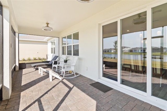 sunroom / solarium featuring a water view