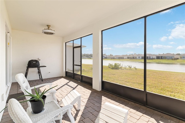 unfurnished sunroom featuring a water view