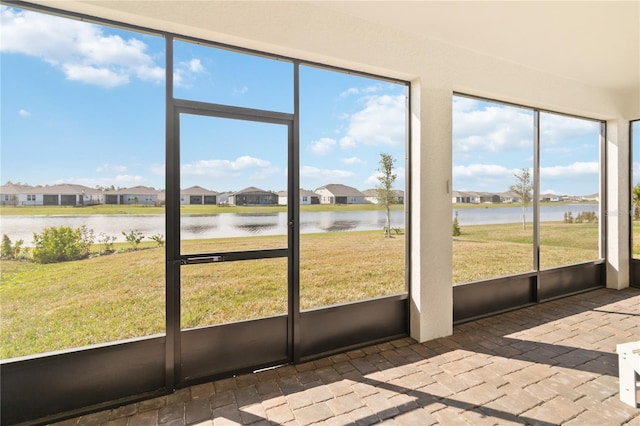 unfurnished sunroom featuring a water view