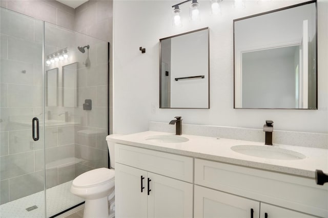 full bathroom featuring a stall shower, a sink, and double vanity