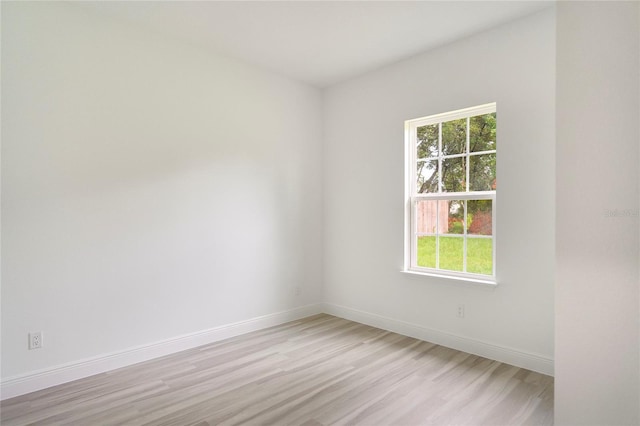 unfurnished room with light wood finished floors and baseboards