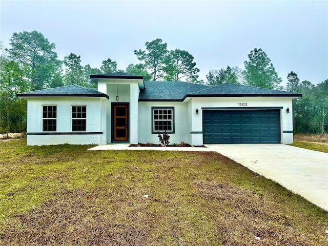 view of front of home with a garage, a shingled roof, concrete driveway, a front yard, and stucco siding