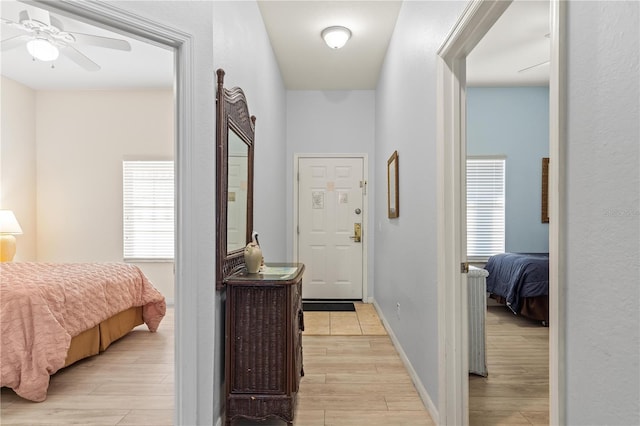 hall with a healthy amount of sunlight and light wood-type flooring