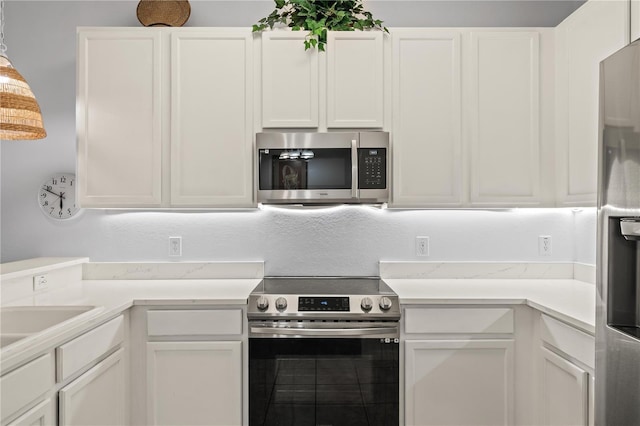 kitchen with white cabinetry and appliances with stainless steel finishes