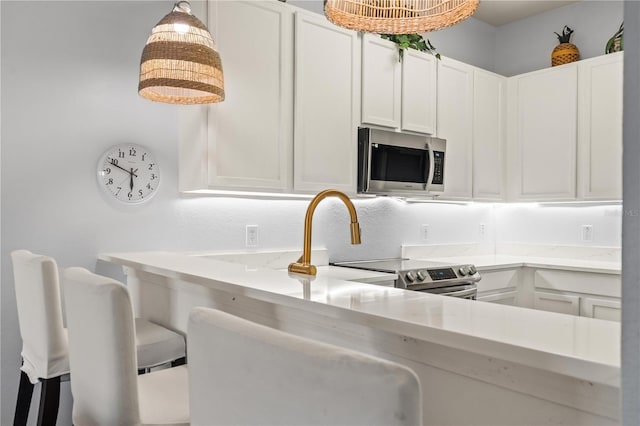 kitchen with white cabinetry, hanging light fixtures, and light stone countertops