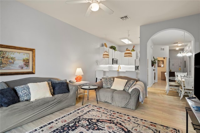 living room featuring ceiling fan and light hardwood / wood-style flooring