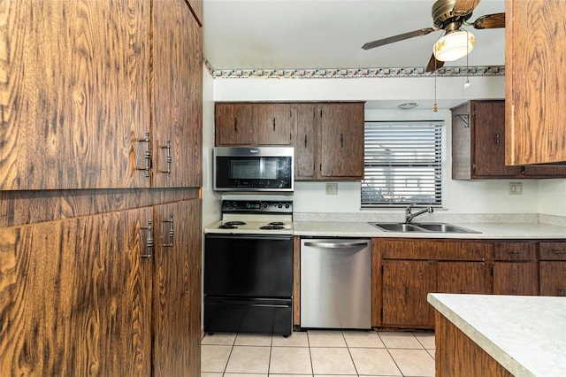 kitchen featuring sink, light tile patterned floors, stainless steel appliances, and ceiling fan