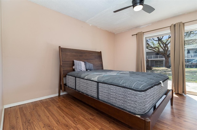 bedroom featuring access to exterior, a textured ceiling, wood-type flooring, and ceiling fan