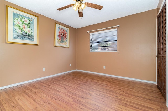 unfurnished bedroom featuring ceiling fan, light hardwood / wood-style floors, and a closet