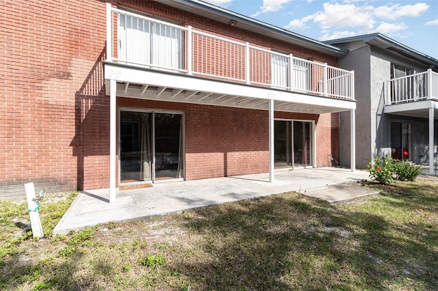 back of property with a lawn and a patio