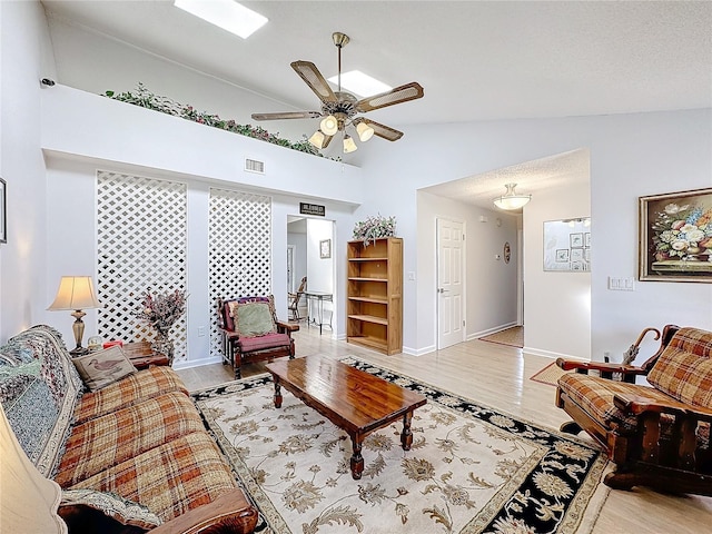 living room featuring ceiling fan, vaulted ceiling, and light hardwood / wood-style flooring