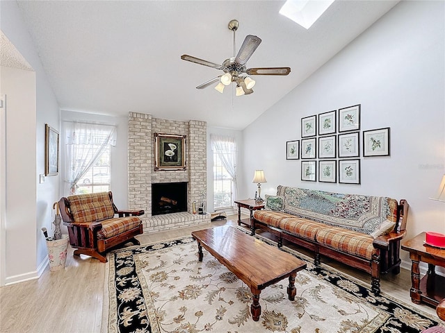 living room with a fireplace, plenty of natural light, light hardwood / wood-style floors, and vaulted ceiling