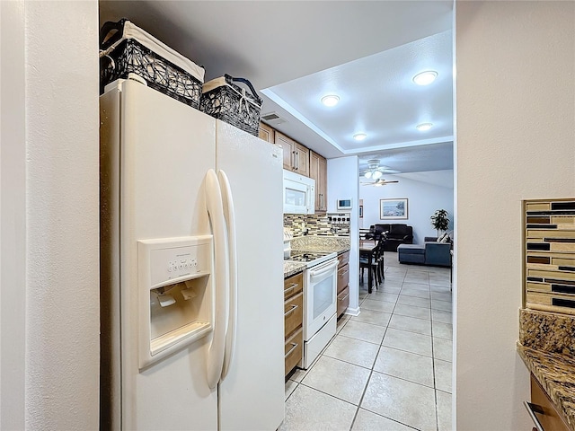 kitchen featuring decorative backsplash, light tile patterned floors, ceiling fan, light stone counters, and white appliances