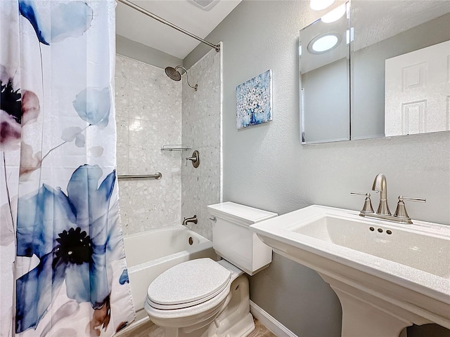 full bathroom with sink, shower / bath combo with shower curtain, and toilet