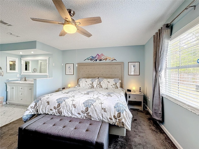 bedroom with ceiling fan, sink, and a textured ceiling