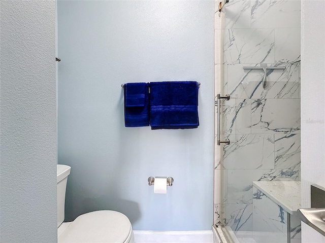 bathroom featuring tiled shower and toilet