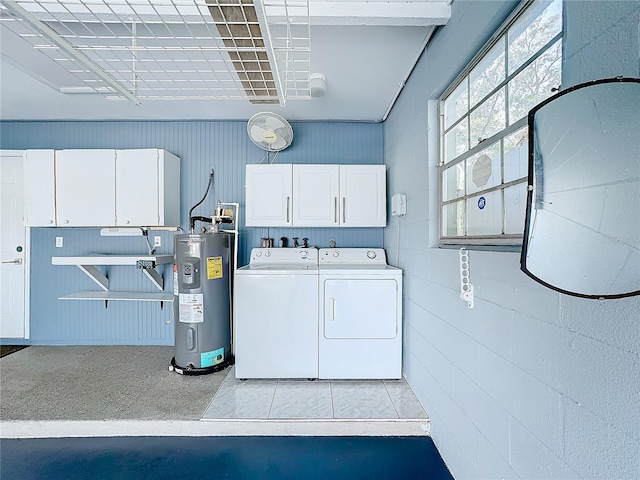 clothes washing area with cabinets, independent washer and dryer, and water heater