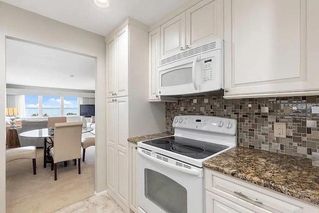 kitchen featuring backsplash, white cabinets, white appliances, and dark stone counters