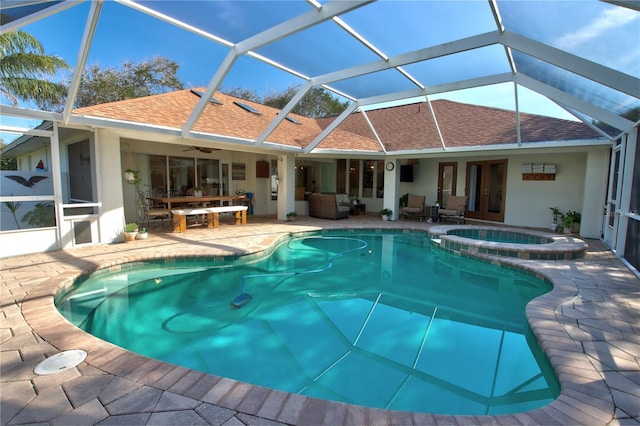 view of swimming pool featuring glass enclosure, a patio, a pool with connected hot tub, and ceiling fan