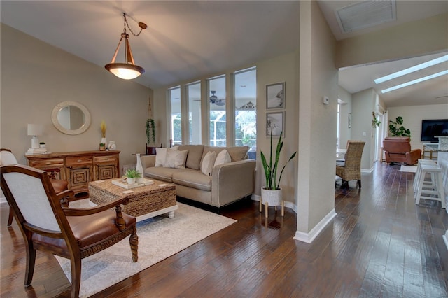 living area featuring visible vents, vaulted ceiling with skylight, and dark wood-style flooring