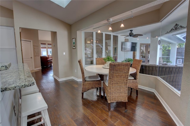 dining area with baseboards, lofted ceiling, dark wood-type flooring, and a ceiling fan