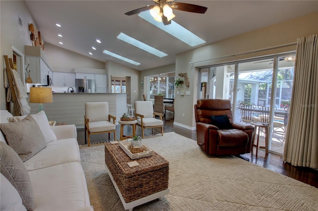 living room featuring wood finished floors, a skylight, recessed lighting, and baseboards