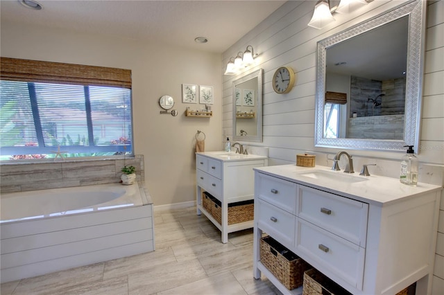 bathroom with a sink, tiled shower, and plenty of natural light