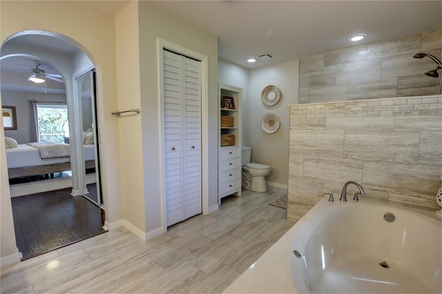 bathroom featuring visible vents, a ceiling fan, ensuite bathroom, a jetted tub, and a closet