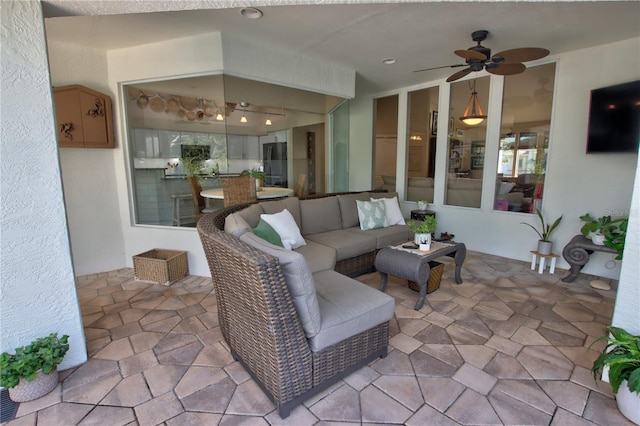 living room with ceiling fan, vaulted ceiling, and stone finish floor