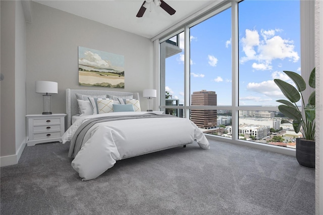 bedroom with dark carpet, a wall of windows, and ceiling fan