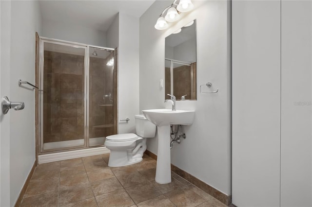 bathroom featuring toilet, tile patterned flooring, and a shower with door