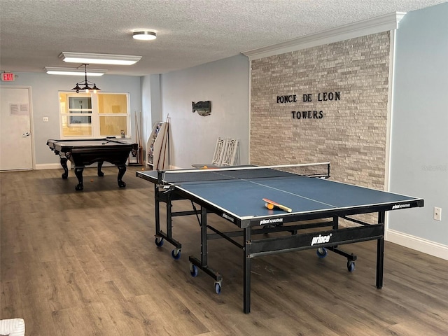 playroom featuring billiards, brick wall, hardwood / wood-style floors, and a textured ceiling