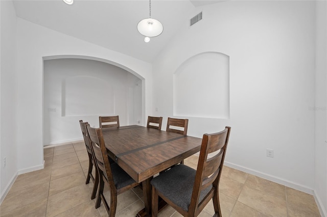 tiled dining space with high vaulted ceiling