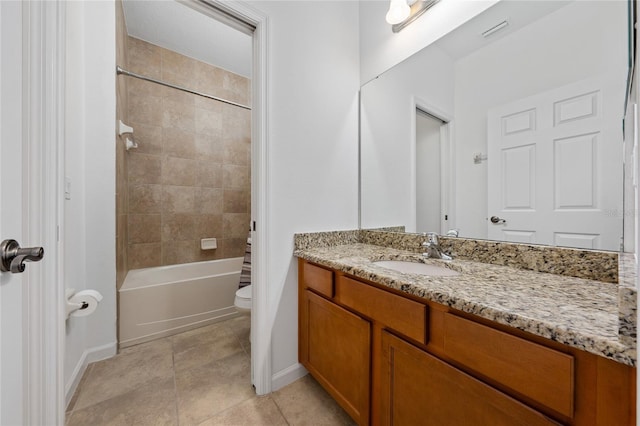 full bathroom featuring tile patterned flooring, tiled shower / bath, vanity, and toilet