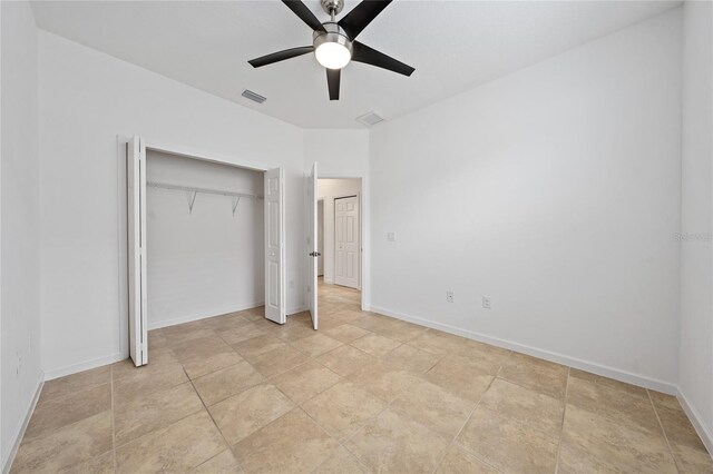 unfurnished bedroom with ceiling fan and a closet