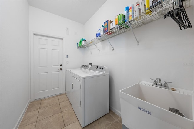 washroom featuring washer and clothes dryer, sink, and light tile patterned floors