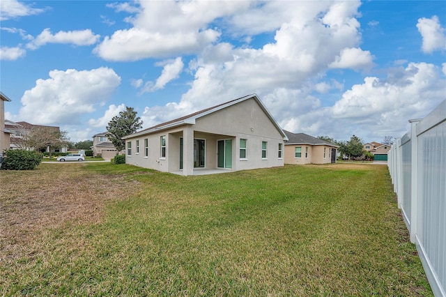 rear view of property featuring a yard and a patio